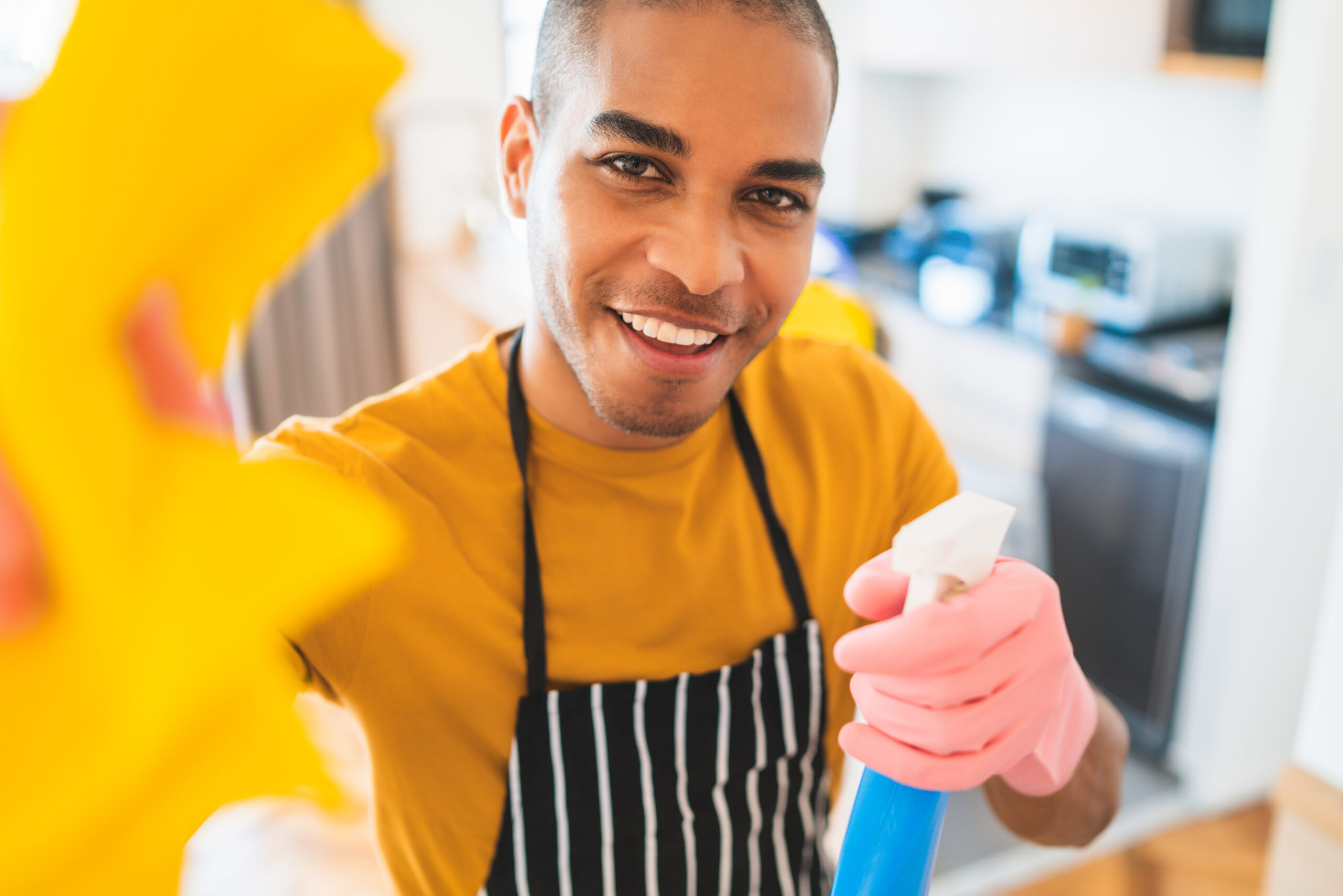 Close up of young latin man cleaning at new home. Housekeeping and cleaning concept.